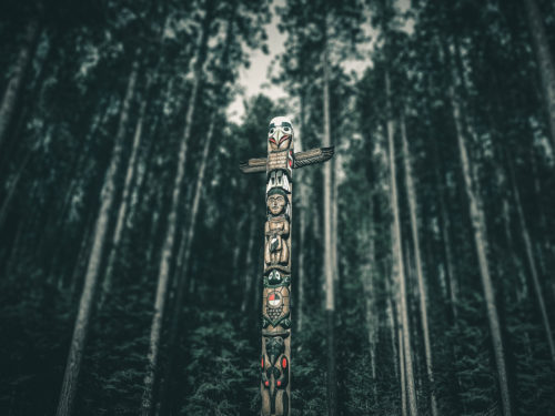 A totem pole in the middle of a forest.