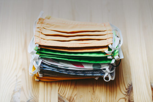A stack of face masks on a wooden table.