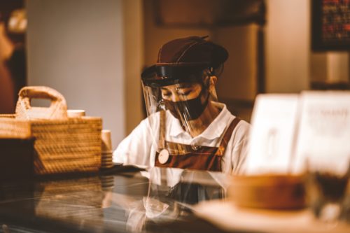 A woman wearing a face mask at a coffee shop.