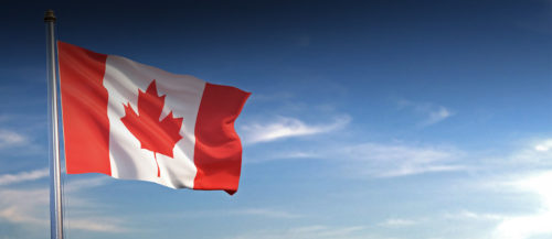A canadian flag flying in the wind.