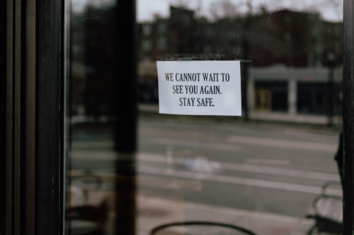 A sign in the window of a restaurant.