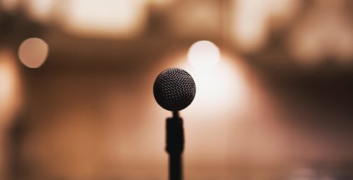 A microphone in front of a blurred background.