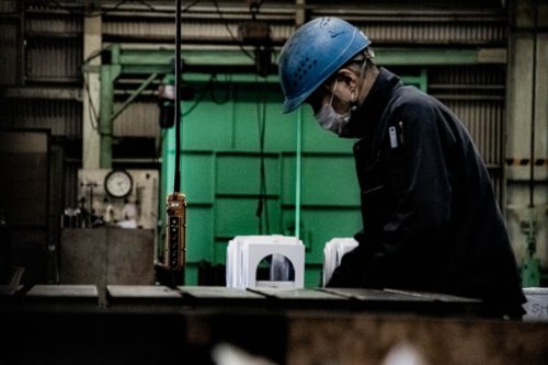 A worker in a factory wearing a hard hat.